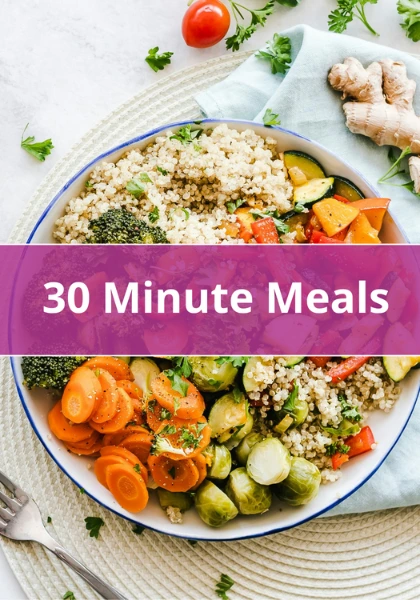 Healthy quinoa bowl with colorful vegetables including carrots, zucchini, and broccoli on a white plate.