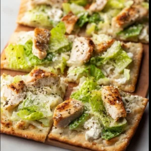 Chicken Caesar Flatbread topped with grilled chicken, romaine, and Caesar dressing.