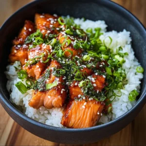 Crispy salmon rice bowl garnished with vegetables and sauces.