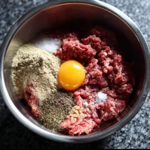 Juicy pure beef burgers on a grill garnished with fresh toppings