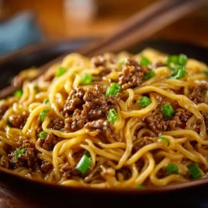 Plate of Mongolian Ground Beef Noodles garnished with green onions.